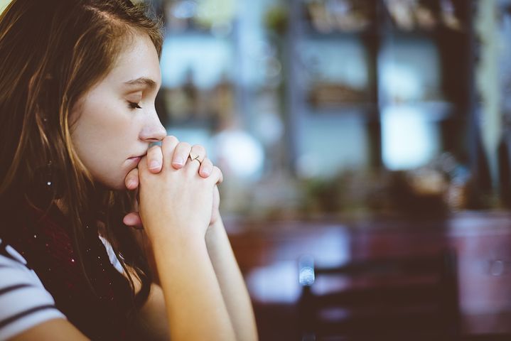 woman praying with her eyes closed