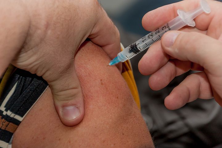 man receiving a corporate flu vaccination